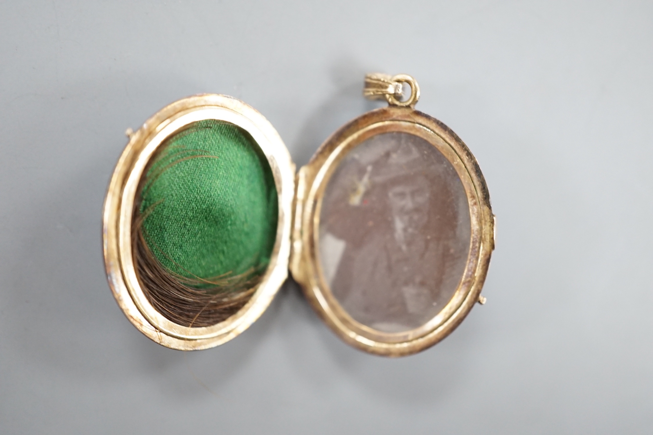 A 19th century yellow metal miniature oval portrait mourning brooch, 54mm, two enamelled lockets(a.f.) and one other small pendant.